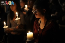 Natalynn Rivis, a student at University of Nevada Las Vegas, right, takes part in a vigil Monday, Oct. 2, 2017, in Las Vegas. A gunman on the 32nd floor of the Mandalay Bay casino hotel rained automatic weapons fire down on the crowd of over 22,000.