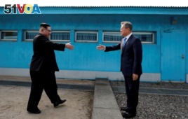 FILE - South Korean President Moon Jae-in and North Korean leader Kim Jong Un, left, are about to shake hands on their first meeting at the truce village of Panmunjom inside the demilitarized zone separating the two Koreas, South Korea, April 27, 2018.