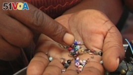 An entrepreneur sorts beads in Haiti.