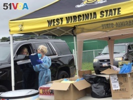 Parents and students arrive in their vehicles for health screenings and temperature checks before moving belongings into residence halls at West Virginia State University campus Friday, July 31, 2020, in Institute, W. Va. (AP Photo/John Raby)