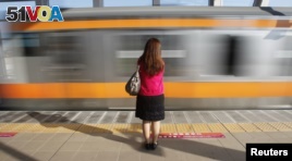 A woman waits to board a passenger train car for women only in Tokyo October 2011. The East Japan Railway company and other railway companies, introduced the 'women only' train cars in 2002 as part of efforts to deal with the problem men who sexually harass female passengers.  REUTERS/Yuriko Nakao