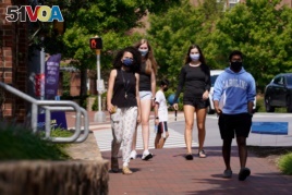 Students wear masks on campus at the University of North Carolina in Chapel Hill, N.C., Tuesday, Aug. 18, 2020. The university announced that it would cancel all in-person undergraduate learning starting on Wednesday following a cluster of COVID-19