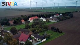 Wind turbines turn near the village of Feldheim, rear left, near Treuenbrietzen, Germany, Wednesday, Sept. 28, 2022. (AP Photo/Michael Sohn)