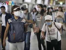 Passengers wearing masks as a precaution against the MERS virus make their way after they got off a train at a subway station in Seoul, South Korea, June 18, 2015.
