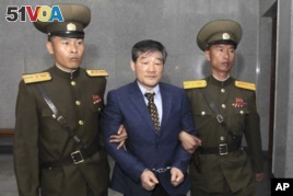 Kim Dong Chul, center, a U.S. citizen detained in North Korea, is shown being taken to his trial Friday, April 29, 2016, in Pyongyang, North Korea. (AP Photo/Kim Kwang Hyon)