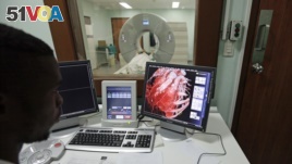 FILE - A doctor checks a screen showing a graphical representation of a human heart. A new study suggests that patients who see their clogged arteries are more likely to make and keep a heart-healthy lifestyle.