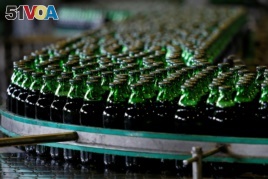 FILE - Bottles of beer move along a production line at a factory of Saigon Beer Corporation (Sabeco) in Hanoi, Vietnam, June 23, 2017.