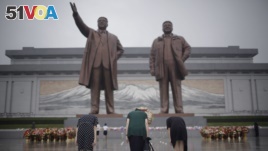North Korean women bow to pay their respects to their late leaders Kim Il Sung and Kim Jong Il at Munsu Hill on Thursday, July 27, 2017, in Pyongyang, North Korea as part of celebrations for the 64th anniversary of the armistice that ended the Korean War. (AP Photo/Wong Maye-E)