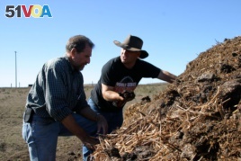 FILE: Jeffrey Creque (L) examines Marin Carbon Project ranch partner Loren Poncia's (R) compost at the Stemple Creek Ranch before spreading it on the area.