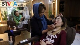 Beauticians apply makeup on customers at Ms. Sadat's Beauty Salon in Kabul, Afghanistan, Sunday, April 25, 2021. Kabul's young working women say they fear their dreams may be short-lived if the Taliban return to Kabul, even if peacefully as part of a new