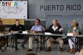 President Donald Trump and first lady Melania Trump participate in a briefing on hurricane recovery efforts with first responders at Luis Muniz Air National Guard Base, Tuesday, Oct. 3, 2017, in San Juan, Puerto Rico