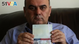 Fuad Sharef Suleman shows his US immigrant visa in Arbil, the capital of the Kurdish autonomous region in northern Iraq, on January 30, 2017 after returning to Iraq from Egypt, where him and his family were prevented from boarding a plane to the U.S. foll
