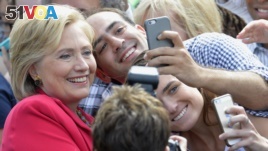 Democratic presidential candidate Hillary Rodham Clinton poses for a photo with two of her supporters on the campus of Case Western Reserve University in Cleveland.
