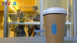 In this Thursday, Dec. 12, 2019 photo, a Blue Bottle Coffee paper to-go cup rests on a table outside one of their cafes in San Francisco. The Oakland-based chain says it's getting rid of disposable cups at two locations next year.