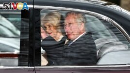Britain's King Charles III and Britain's Queen Camilla wave as they leave by car from Clarence House, traveling to Buckingham Palace, in London on February 6, 2024. (Photo by HENRY NICHOLLS / AFP)