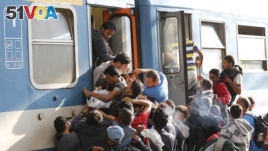 Migrants struggle to board a train at the railway station in Budapest, Hungary, Thursday, Sept. 3, 2015.