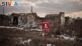 FILE - A sign that reads Mines is placed on the side of the road in the village of Kamyanka, Ukraine, on Feb. 19, 2023. In this war-scarred city in Ukraine's northeast, residents scrutinize every step for land mines.(Vadim Ghirda/AP Photo)