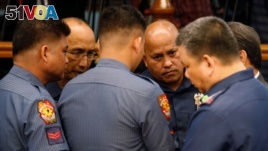 Philippine National Police chief Director-General Ronald dela Rosa (2nd-R) talks to fellow police officers during a Senate hearing regarding people killed during a crackdown on illegal drugs in Pasay, Metro Manila, Philippines, Aug. 23, 2016.