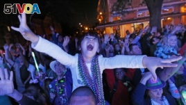 FILE - A young reveler scream for beads during the Krewe of Endymion Mardi Gras parade in New Orleans, Saturday, Feb. 25, 2017. (AP Photo/Gerald Herbert)