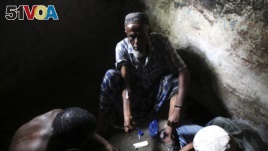FILE - A heroin addict injects heroin in Lamu, Kenya, Nov. 21, 2014.