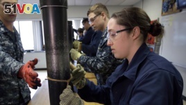 In this April 26, 2017 file photo, U.S. Navy Ensign Megan Stevenson, right, of Raymond, Maine, trains at patching high-pressure pipe leaks during a class at the Naval Submarine School, in Groton, Conn. (AP Photo/Steven Senne, File)