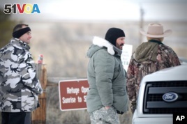 Protesters roam the Malheur National Wildlife headquarters in Burns, Ore., on Sunday, Jan 3, 2016. Armed protesters took over the Malheur National Wildlife Refuge on Saturday after participating in a peaceful rally over the prison sentences of local ranchers Dwight and Steven Hammond. (Mark Graves/The Oregonian via AP)
