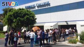 FILE - Students wait outside Everest College in Industry, Calif., hoping to get information on loan forgiveness, April 28, 2015. Everest was a part of Corinthian Colleges, which shut its U.S. campuses in April 2015, displacing 16,000 students.