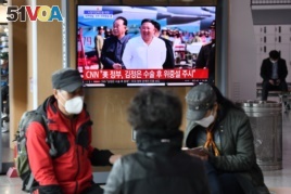 People watch a television news broadcast showing file footage of North Korean leader Kim Jong Un, at a railway station in Seoul on April 21, 2020.