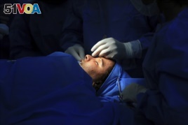 In this Tuesday, Nov. 6, 2018 photo, plastic surgeon Dr. Abbas al-Sahan performs reconstructive surgery on Saja Ahmed Saleem, in Baghdad, Iraq. (AP Photo/Hadi Mizban)