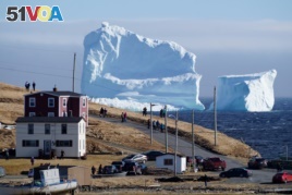 Residents view the first iceberg of the season as it passes the South Shore, also known as 