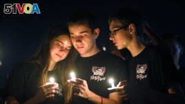 Attendees comfort each other at a candlelight vigil for the victims of the shooting at Marjory Stoneman Douglas High School, Feb. 15, 2018, in Parkland, Fla. 