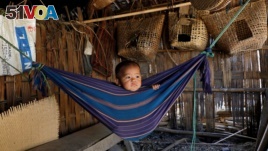 Tina Chakma, a six-month-old baby girl plays in an improvised hammock inside her parents' house on the outskirts of Agartala, India, March 20, 2018.
