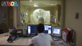 FILE - In this May 19, 2015 file photo, a nuclear medicine technologist makes a PET scan of a patient at Georgetown University Hospital in Washington. Depression has long been linked to certain cognitive problems. (AP Photo/Evan Vucci)