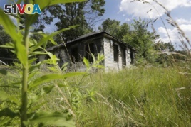 FILE - An abandoned house with an overgrown lot is seen in Brightmoor, a neighborhood on Detroit's northwest side, July 19, 2013.