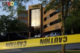 Crime scene tape surrounds a building housing The Capital Gazette newspaper's offices, Friday, June 29, 2018, in Annapolis, Md.