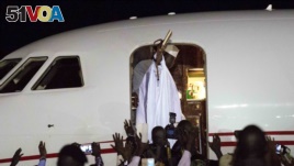Gambia's defeated leader Yahya Jammeh waves to supporters as he departs from Banjul airport, Jan. 21, 2017.