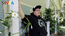 Gavin Grimm leans on a post on his front porch during an interview at his home in Gloucester, Va. Grimm is a transgender student whose demand to use the boys' restrooms has divided the community and prompted a lawsuit.