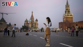 FILE - A young woman checks her smartphone at Red Square in Moscow, Russia, July 2016. (AP Photo/Pavel Golovkin)
