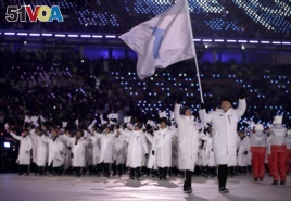 North Korea's Hwang Chung Gum and South Korea's Won Yun-jong carries the flag during the opening ceremony of the 2018 Winter Olympics in Pyeongchang, South Korea, Friday, Feb. 9, 2018. (AP Photo/Vadim Ghirda)