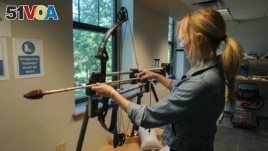 In this June 1, 2017, photo, Michelle Bebber, a PhD archeology student at Kent State University, loads a bow with a recreated ancient arrow in Kent, Ohio.