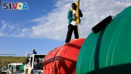A man refills water in a jojo tank loaded in one of the trucks hired to deliver emergency water to residents, at Blue Gum Bush in Qwaqwa, in the Free State province, South Africa, February 5, 2020. Picture taken February, 5, 2020. REUTERS/Siphiwe Sibeko -