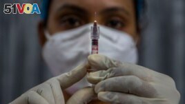 FILE - In this Friday, Jan. 8, 2021, file photo, a health worker checks a syringe before performing a trial run of COVID-19 vaccine delivery system, as India's prepare to kick off the coronavirus vaccination drive on Jan. 16, in Gauhati, India. (AP Photo/Anupam Nath, File)