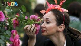 FILE - Paola Orsero of Alassio, Italy smells a rose at the Royal Horticultural Society's Chelsea Flower Show in London, Britain May 19, 2015. (REUTERS/Suzanne Plunkett)
