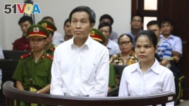 Vietnamese prominent blogger Nguyen Huu Vinh, left, and his colleague Nguyen Thi Minh Thuy stand trial at the Higher People's Court in Hanoi, Vietnam, Thursday, Sept. 22, 2016.