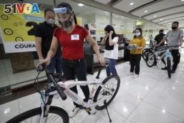 Benjamin Canlas Courage to be Kind Foundation founder Dr. George Canlas (left) watches as one of the winners pushes a bicycle during the award ceremony in Manila, Philippines, July 11, 2020.