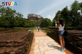 A tourist take pictures of the UNESCO listed World Heritage Site Sigiriya Rock Fortress in Sigiriya, Sri Lanka October 11, 2018. REUTERS/Dinuka Liyanawatte