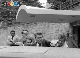 Reagan, pictured here entering the car that took him to the hospital, did not realize at first that he was shot. The gunman was found to be too mentally unstable to be held responsible for the crime. (AP Photo/Ron Edmonds)
