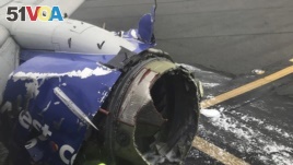 The engine on a Southwest Airlines plane is inspected as it sits on the runway at the Philadelphia International Airport after it made an emergency landing in Philadelphia, April 17, 2018. (Amanda Bourman via AP)