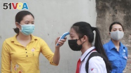 A student is scanned for temperature before entering Dinh Cong secondary school in Hanoi, Vietnam Monday, May 4, 2020.