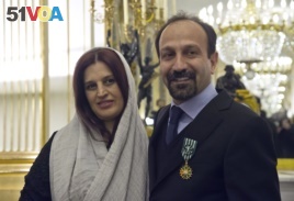 FILE - Iranian film director Asghar Farhadi and his wife, Parisa, pose after he was awarded the Officer of the Order of Arts and Letters medal, at the French Ministry of Culture, in Paris, France, Feb. 27, 2014.